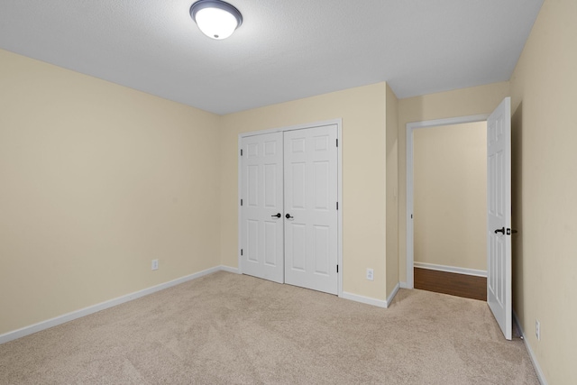 unfurnished bedroom featuring a closet, carpet flooring, and baseboards