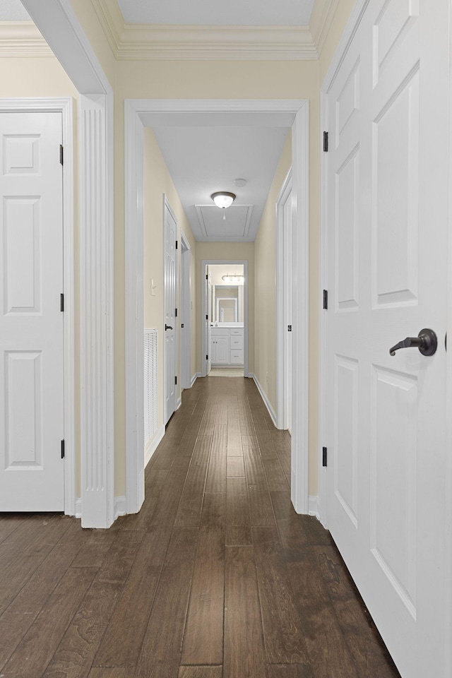 corridor featuring baseboards, dark wood finished floors, and ornamental molding