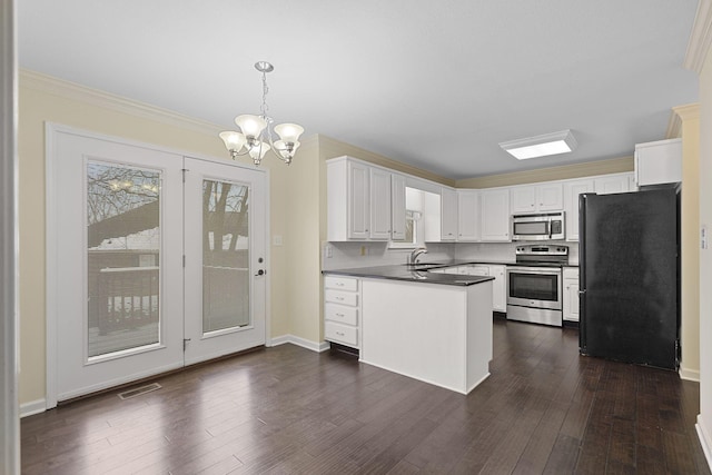 kitchen featuring visible vents, dark countertops, appliances with stainless steel finishes, dark wood-type flooring, and a sink