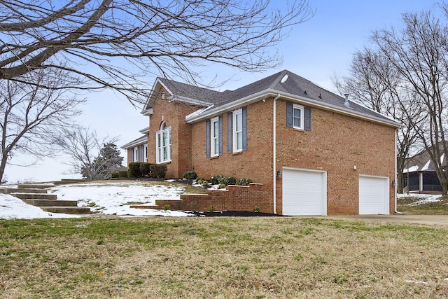 view of home's exterior with a garage, brick siding, driveway, and a lawn