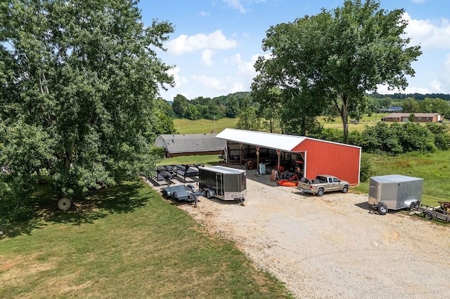 view of car parking with a detached garage and an outbuilding