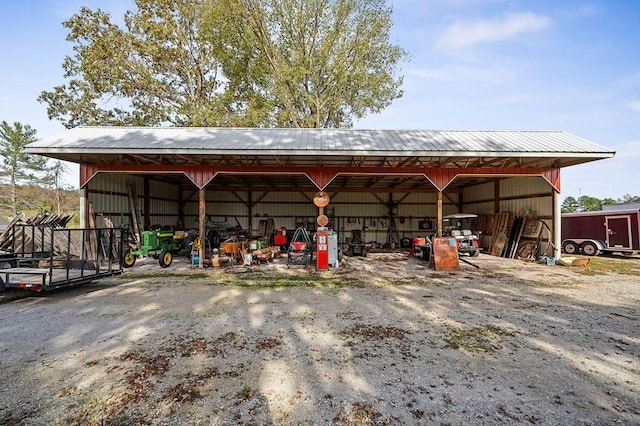 view of pole building with a carport and driveway