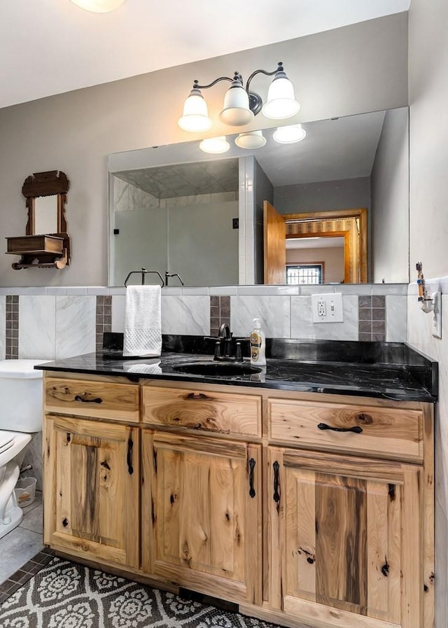 bathroom featuring toilet, backsplash, vanity, and tile patterned floors