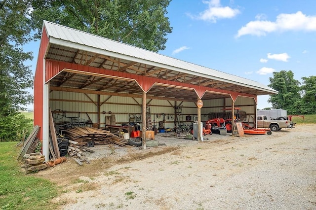 view of vehicle parking with a pole building, driveway, and a detached carport