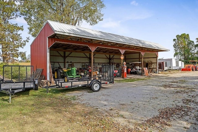 view of pole building with a carport and driveway