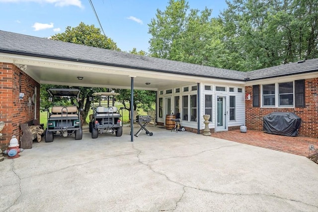 view of patio featuring a carport, grilling area, and a sunroom