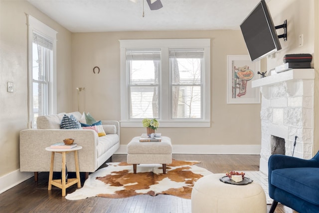 living area featuring a healthy amount of sunlight, a fireplace, and wood finished floors