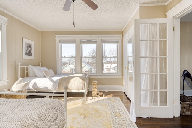 bedroom featuring ornamental molding, dark wood-type flooring, and a textured ceiling