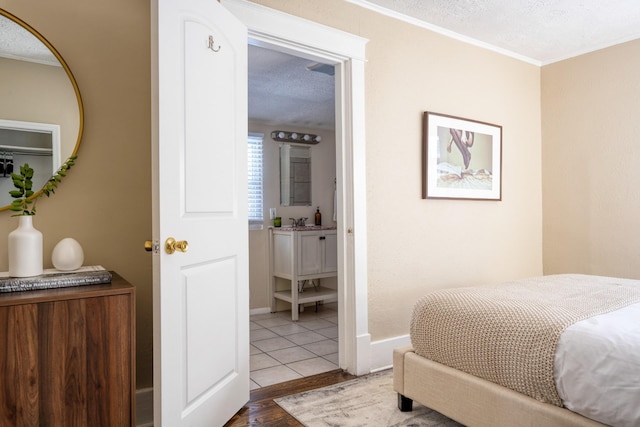 bedroom with baseboards, tile patterned flooring, ornamental molding, and a textured ceiling