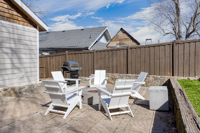 view of patio featuring an outdoor fire pit, a fenced backyard, and a grill