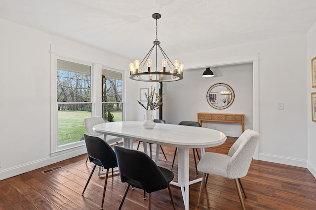 dining area featuring baseboards, visible vents, a chandelier, and dark wood-style flooring