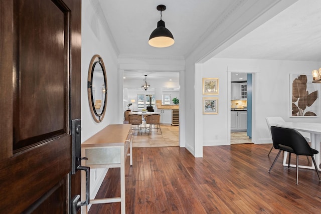 foyer with crown molding, baseboards, and wood finished floors