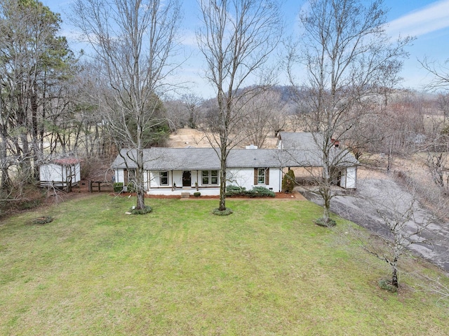 view of front of home with aphalt driveway and a front lawn