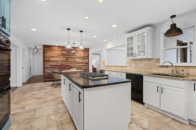 kitchen with a sink, a kitchen island, white cabinetry, black appliances, and pendant lighting