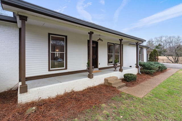 view of front of property featuring covered porch and brick siding