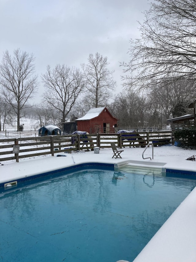 snow covered pool with an outdoor pool and fence