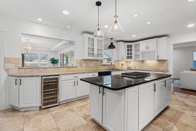 kitchen with glass insert cabinets, wine cooler, white cabinets, and dark stone countertops