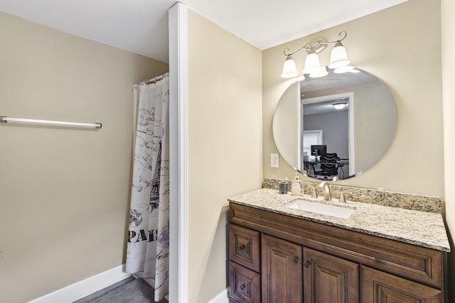 full bathroom with vanity and baseboards