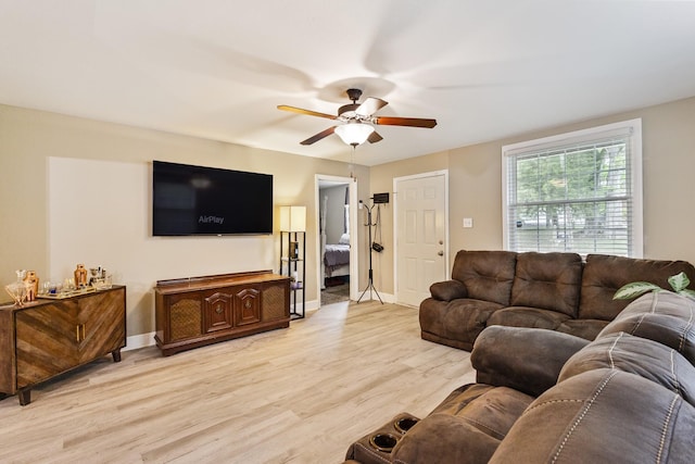 living room with ceiling fan, light wood-type flooring, and baseboards