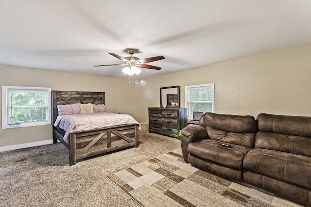 carpeted bedroom with multiple windows, ceiling fan, and baseboards