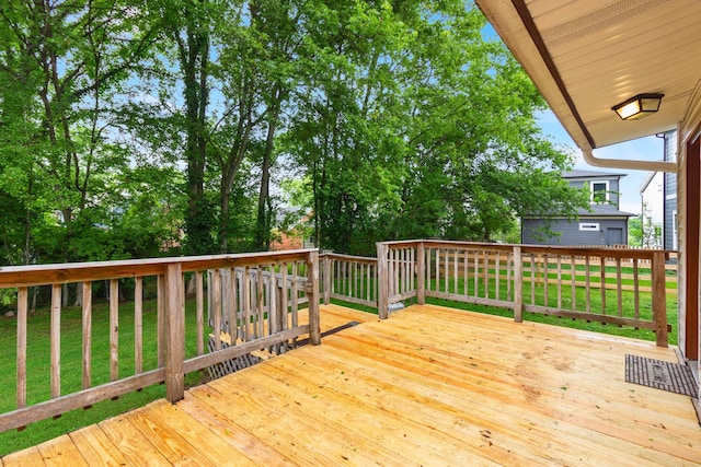 wooden terrace featuring a lawn