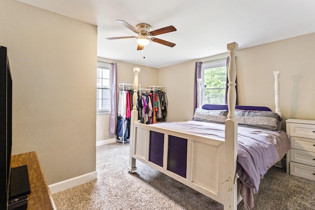 bedroom with a ceiling fan, multiple windows, light carpet, and baseboards