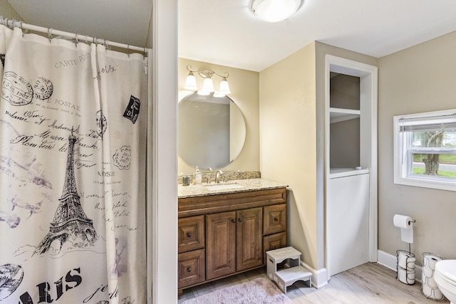 full bath featuring a shower with curtain, wood finished floors, vanity, and baseboards