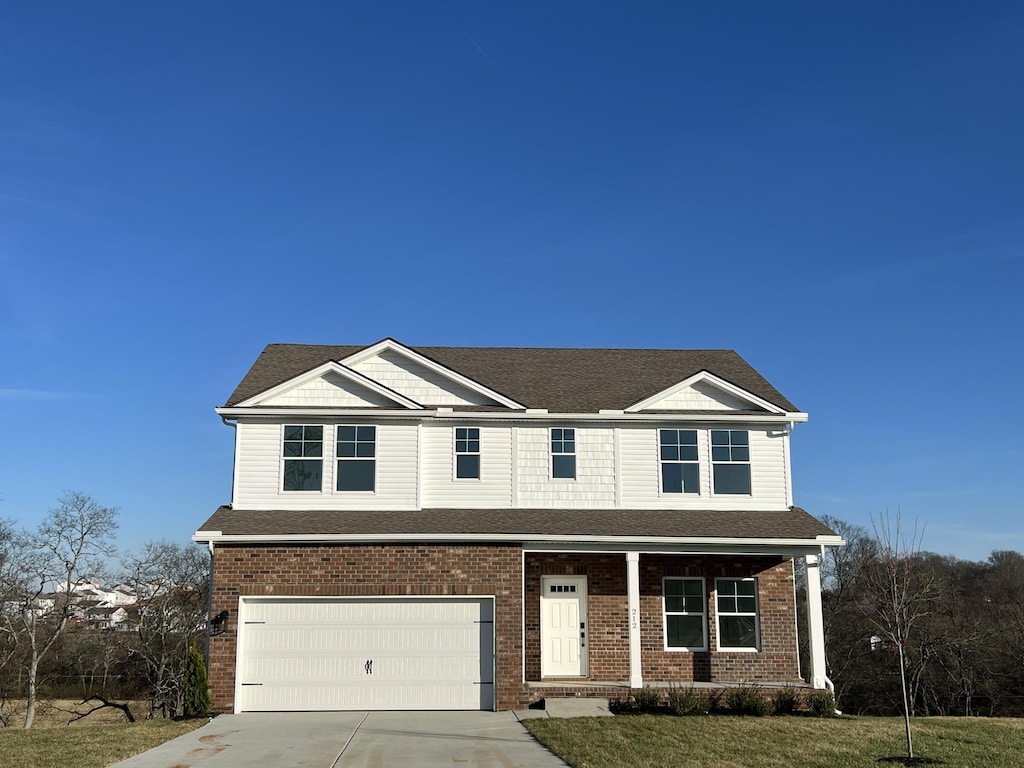 view of front of property with brick siding, concrete driveway, covered porch, an attached garage, and a front yard