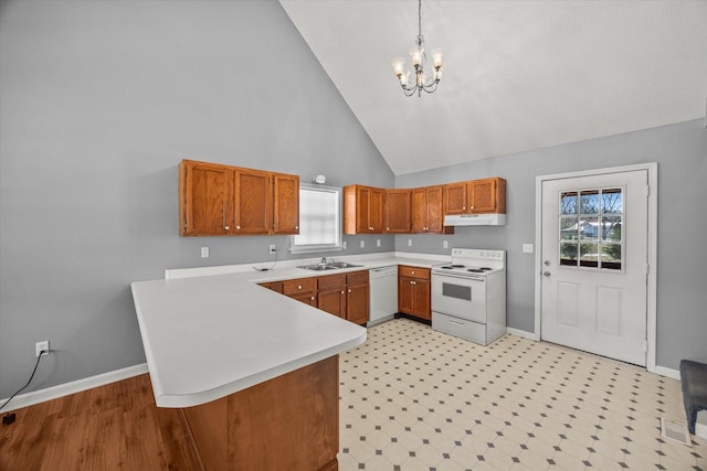 kitchen with light countertops, hanging light fixtures, a peninsula, white appliances, and under cabinet range hood