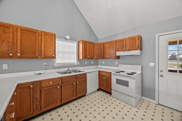 kitchen featuring white appliances, light floors, light countertops, under cabinet range hood, and a sink