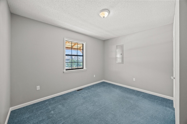 carpeted spare room featuring baseboards, electric panel, visible vents, and a textured ceiling