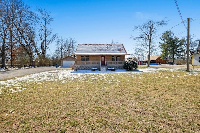 rear view of house featuring covered porch, a lawn, an outdoor structure, and a garage