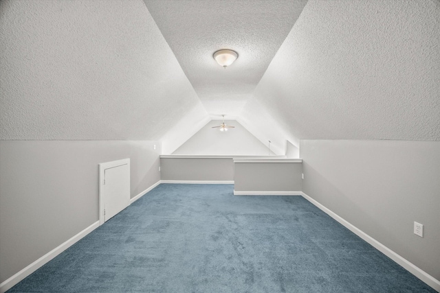 additional living space with lofted ceiling, a textured ceiling, carpet flooring, and baseboards