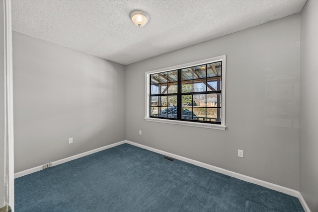 carpeted empty room with baseboards, visible vents, and a textured ceiling