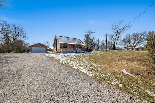 view of front of house with a garage, a porch, and an outbuilding