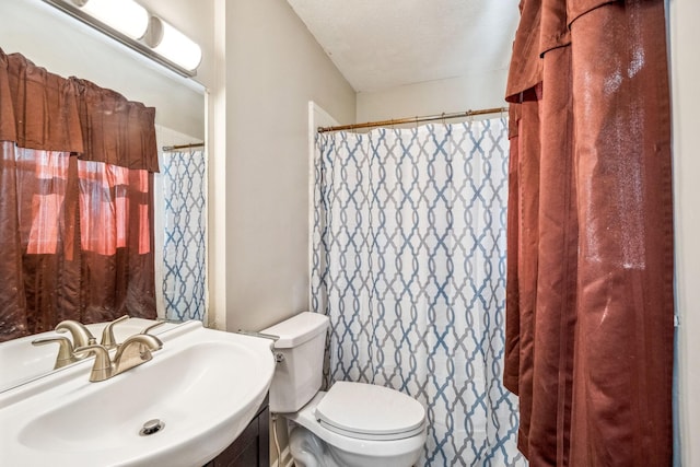 bathroom with curtained shower, vanity, toilet, and a textured ceiling