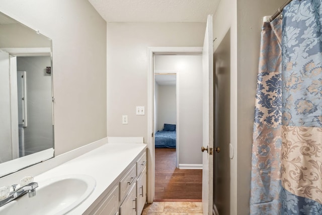 full bath featuring a shower with curtain, vanity, and a textured ceiling