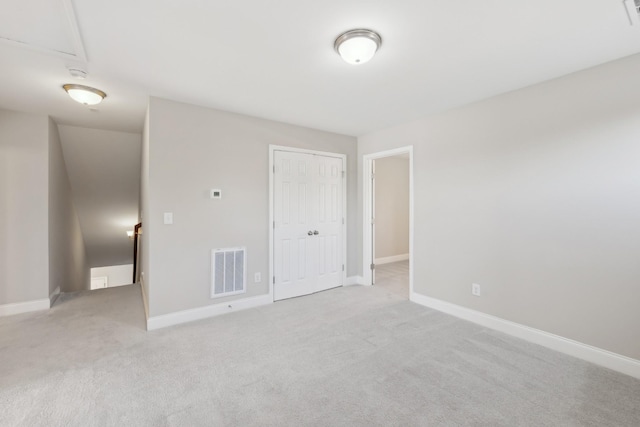 unfurnished bedroom with baseboards, visible vents, and light colored carpet