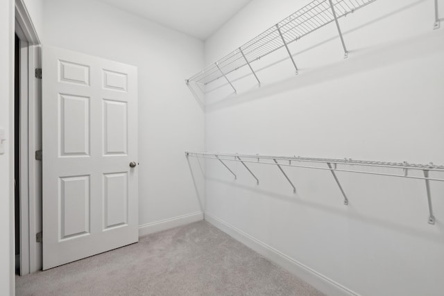 walk in closet featuring light carpet