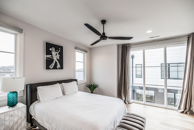 bedroom featuring light wood-type flooring, access to outside, visible vents, and a ceiling fan