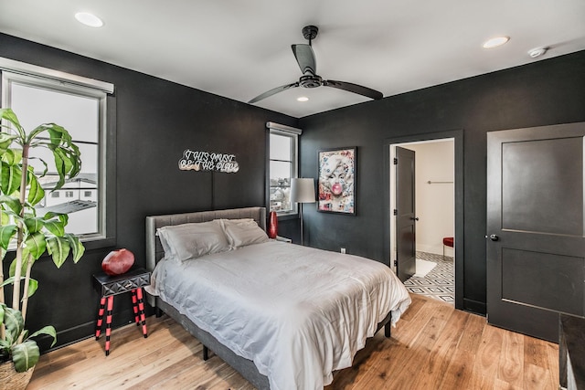 bedroom with light wood-type flooring, ceiling fan, ensuite bathroom, and recessed lighting