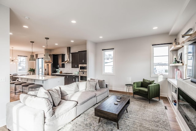 living area featuring recessed lighting, a wealth of natural light, and light wood-style floors