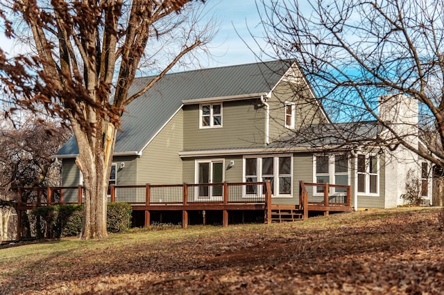 back of property featuring a deck, metal roof, and a chimney