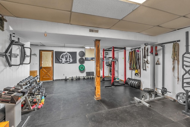 exercise room with a paneled ceiling and visible vents