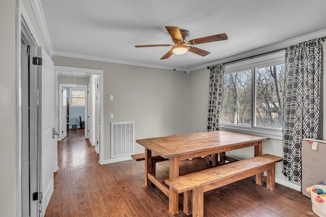 dining room featuring attic access, baseboards, visible vents, wood finished floors, and crown molding