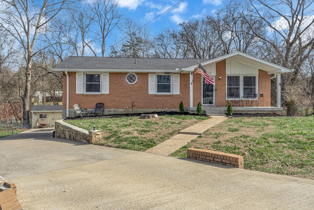 ranch-style home featuring a front yard, brick siding, and roof with shingles