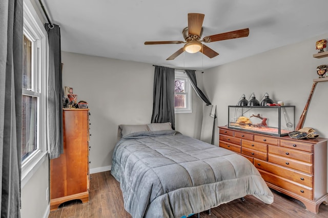 bedroom featuring a ceiling fan, baseboards, and wood finished floors