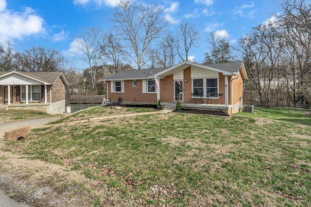 view of front of home featuring cooling unit, covered porch, brick siding, and a front lawn