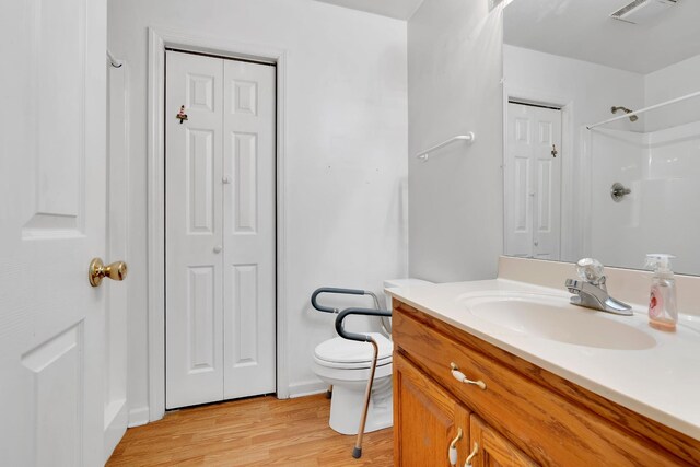 bathroom featuring visible vents, a closet, wood finished floors, and vanity