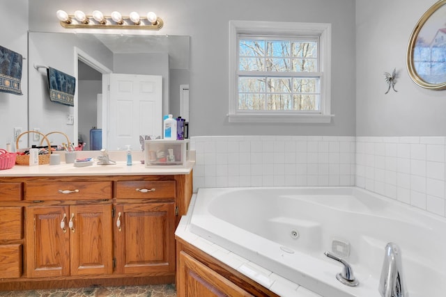 bathroom with a tub with jets and vanity